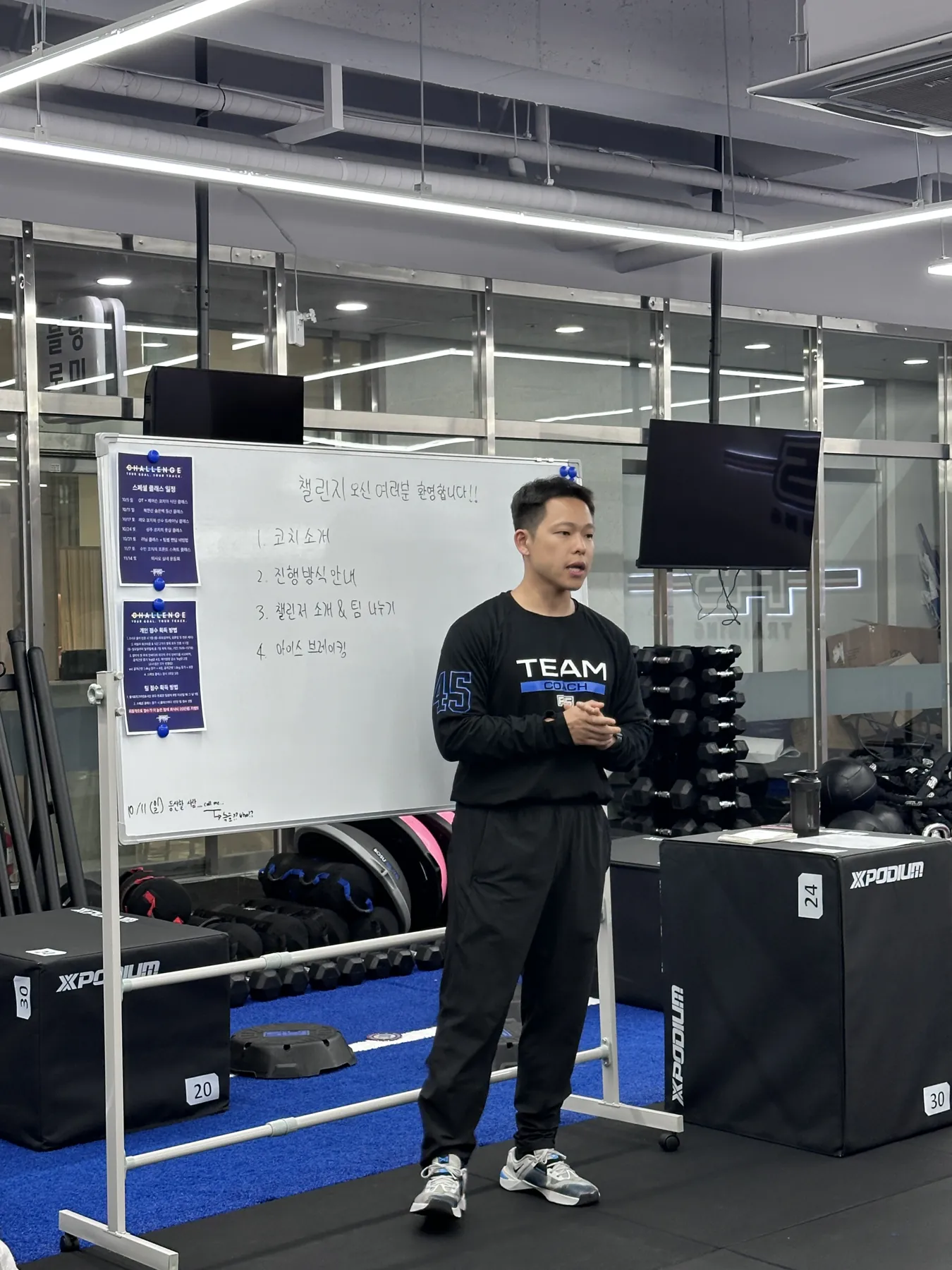 챌린지 브리핑에서 화이트보드 앞에 선 코치